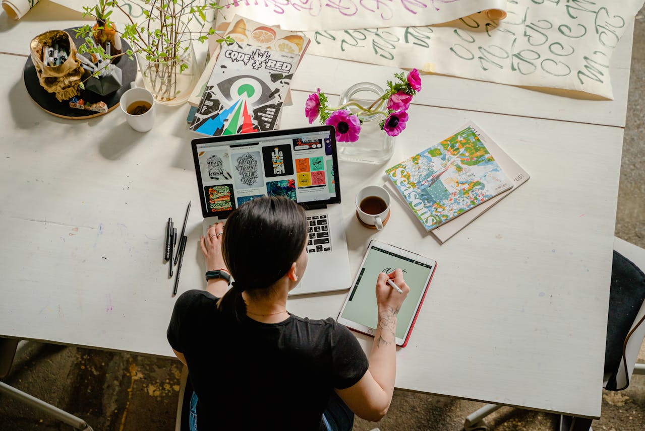 Person working on a laptop designing digital products, representing the process of transforming ideas into sellable digital assets.