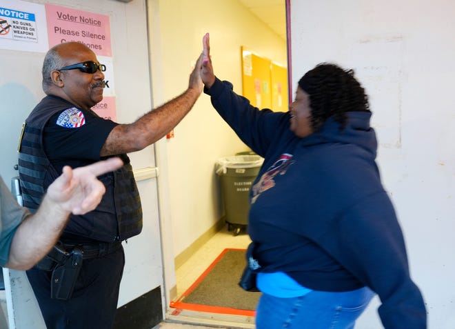 Dorothy Johnson gives a high five to a deputy as she goes in to vote on the first day of early voting at the Oklahoma County Election Board on Oct. 30, 2024.