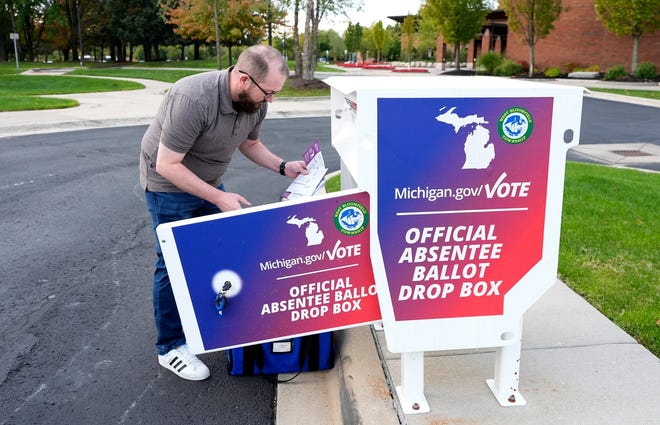 tony Weatherly, a senior election specialist at the West Bloomfield Township, Michigan, offices, takes out many early voting ballots from the drop box on Oct. 8, 2024. Weatherly does this every morning in order to stay on top of checking in the ballots of voting residents so he doesn't end up with a backlog of them as Election Day nears.