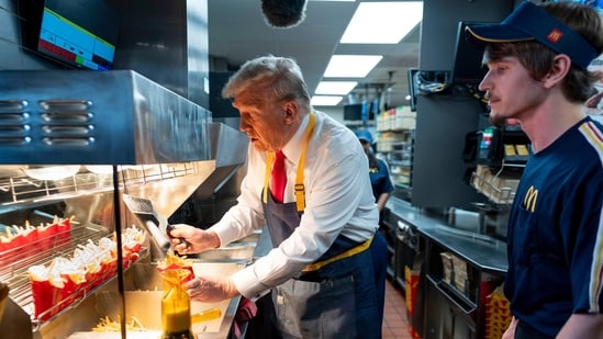 Donald Trump, left, uses a frier as an employee looks on during a visit to McDonald's in Feasterville-Trevose, Pa., Sunday, Oct. 20, 2024. (Doug Mills/The New York Times via AP, Pool)(AP)