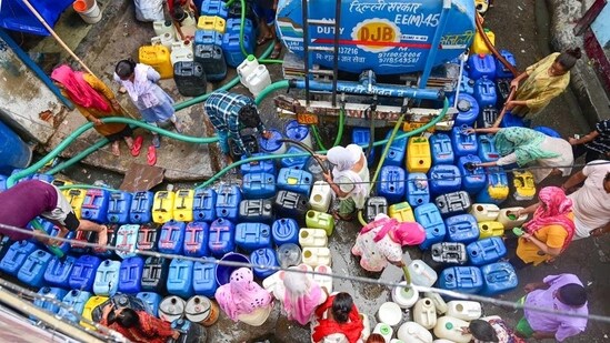 Residents of Kusumpur Pahari line up their containers to fill water from a Delhi Jal Board water tanker. ((Vipin Kumar/HT Photo))