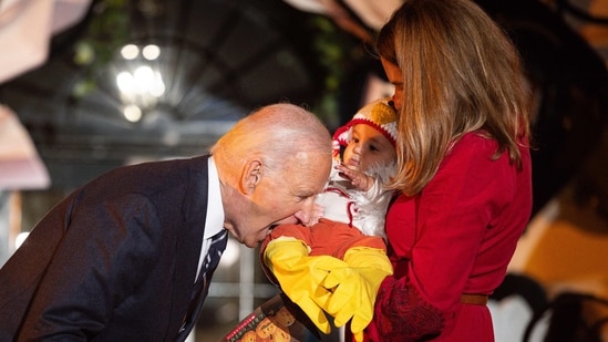 TOPSHOT - US President Joe Biden jokingly bites a baby dressed as a chicken as he hosts a Halloween trick-or-treat event at the South Portico of the White House in Washington, DC, on October 30, 2024. (Photo by Tierney CROSS / AFP)(AFP)