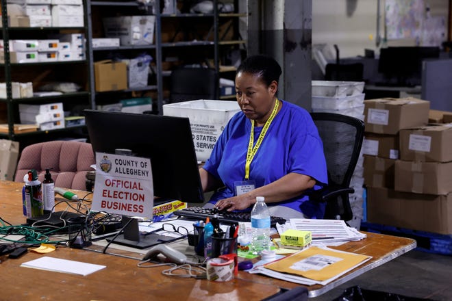 An election worker processes voter registration forms inside the Allegheny County Elections Warehouse in Pittsburgh, Pennsylvania, on Oct. 30, 2024.