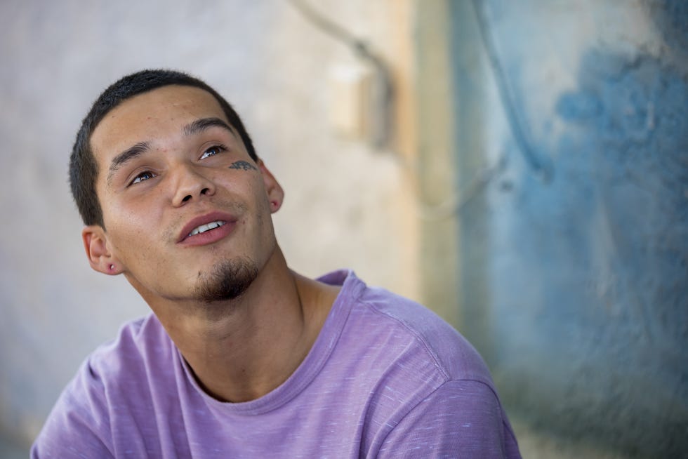 Emerson Linares, 23, a Venezuelan migrant, talks about his dream of traveling the world as he sits on the sidewalk across the street from Sacred Heart Church in El Paso, Texas, on Tuesday, Sept. 24, 2024, where he is staying with other migrants.