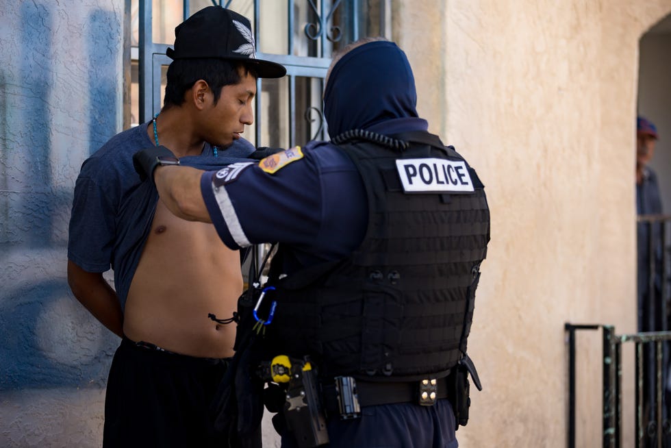 El Paso Police check migrants' tattoos as they patrol the area where migrants are staying in front of Sacred Heart Church on Tuesday, Sept. 24, 2024.