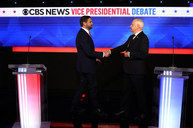 US Senator and Republican vice presidential candidate J.D. Vance (L) and Minnesota Governor and Democratic vice presidential candidate Tim Walz shake hands at the start of the vice presidential debate.