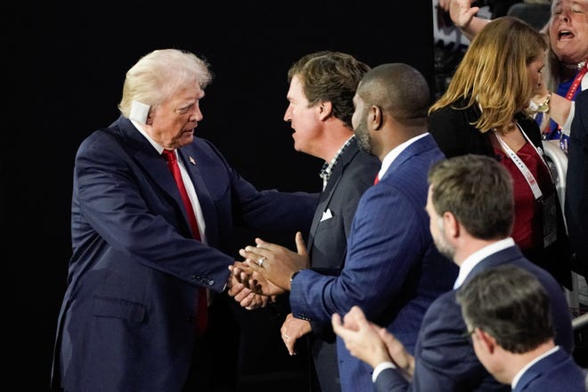 Former President Donald Trump greets Tucker Carlson, Rep. Byron Donalds, Republican vice president nominee JD Vance and Speaker of the House Mike Johnson during the first day of the Republican National Convention on July 15, 2024. The RNC kicked off the first day of the convention with the roll call vote of the states.