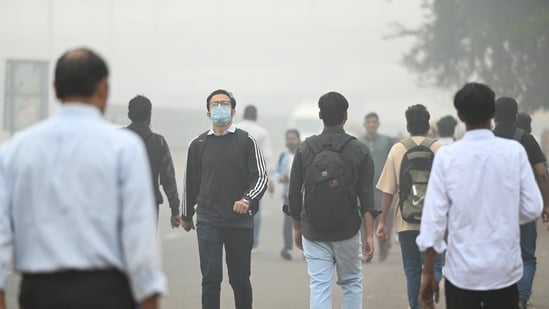 Commuters wear masks to protect themselves from air pollution in Noida on November 13, 2024.(Sunil Ghosh / Hindustan Times)