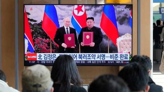 A TV screen shows a file image of North Korean leader Kim Jong Un, right, and Russian President Vladimir Putin in Pyongyang, during a news program at the Seoul Railway Station in Seoul, South Korea, Tuesday, Nov. 12, 2024. (AP Photo/Ahn Young-joon)