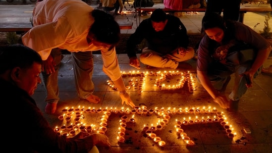 People light 'diyas' to form 'Jaya Bharat' during the Diwali festival celebrations at Lal Chowk in Srinagar on Thursday.(PTI)