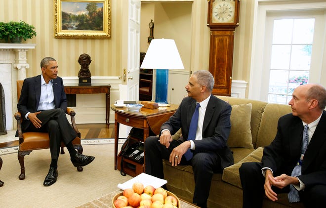 President Barack Obama meets with Attorney General Eric Holder about the situation in Ferguson, Missouri, while White House Counsel Neil Eggleston, right, watches in the Oval Office of the White House in Washington on Aug. 18, 2014.