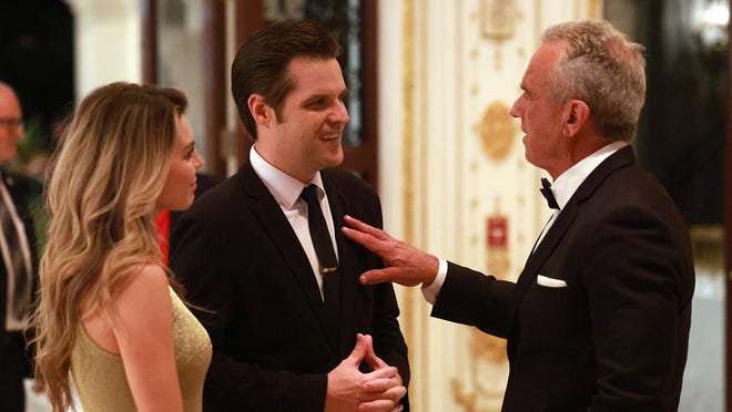 Robert F. Kennedy Jr. (R) talks with former U.S. Rep. Matt Gaetz and his wife Ginger Luckey Gaetz at the America First Policy Institute Gala held at Mar-a-Lago on November 14, 2024 in Palm Beach, Florida.