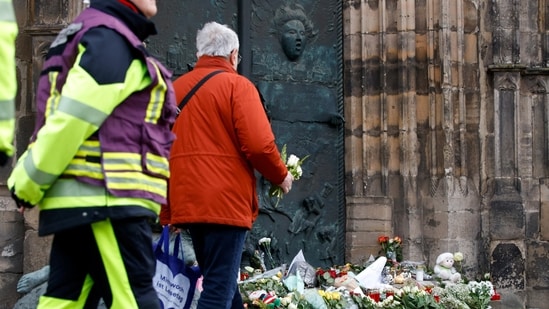 People leave floral tributes by a church near the site where a car drove into a crowd at a Magdeburg Christmas market in Germany.(REUTERS)