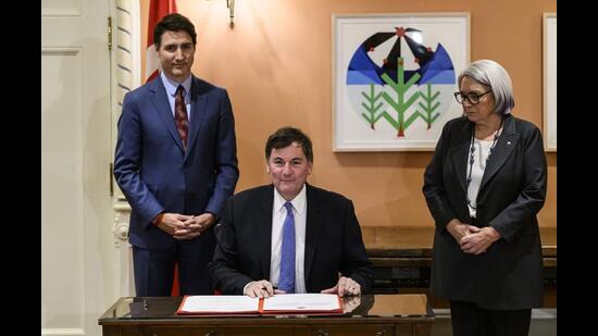 Prime Minister Justin Trudeau (left) and Gov. Gen. Mary Simon look on as Dominic LeBlanc (centre), Minister of Finance, Public Safety and Intergovernmental Affairs, participates in a signing during a swearing in ceremony at Rideau Hall in Ottawa, on Monday. (AP)