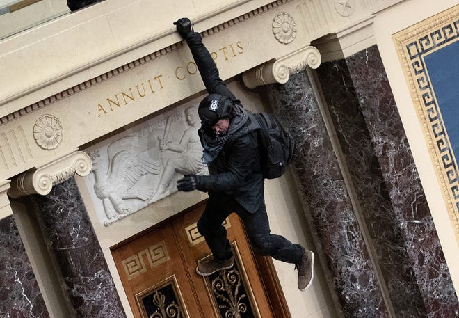 A protester supporting President Donald Trump jumps from the public gallery to the floor of the Senate chamber during the assualt on the U.S. Capitol Building on January 06, 2021 in Washington, DC.