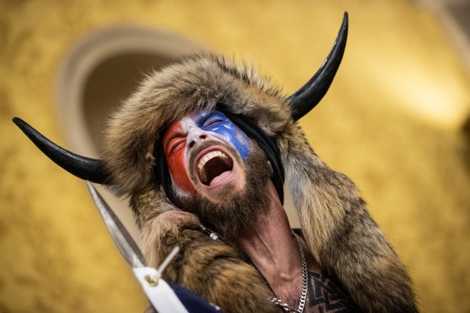 Jacob Chansley, also known as the "QAnon Shaman," screams "Freedom" inside the U.S. Senate chamber after the Capitol was breached by a mob during a joint session of Congress on Jan. 6, 2021 in Washington, DC. Chansley later pleaded guilty to obstruction.