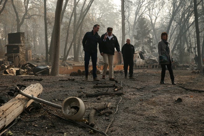 U.S. President Donald Trump visits the charred wreckage of Skyway Villa Mobile Home and RV Park with Governor-elect Gavin Newsom (L), Paradise Mayor Jody Jones (R) and Governor Jerry Brown in Paradise, California, U.S., November 17, 2018.